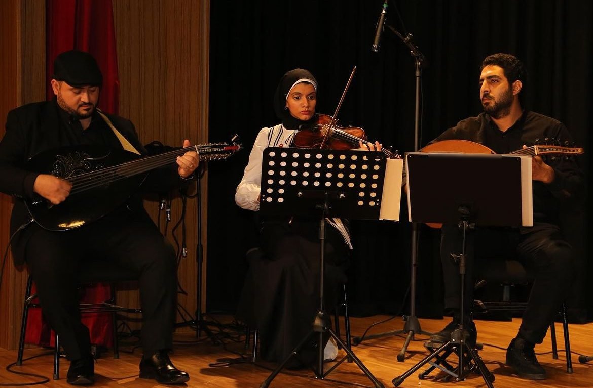 Wael Salah playing oud with a trio on stage: two ouds and a violin